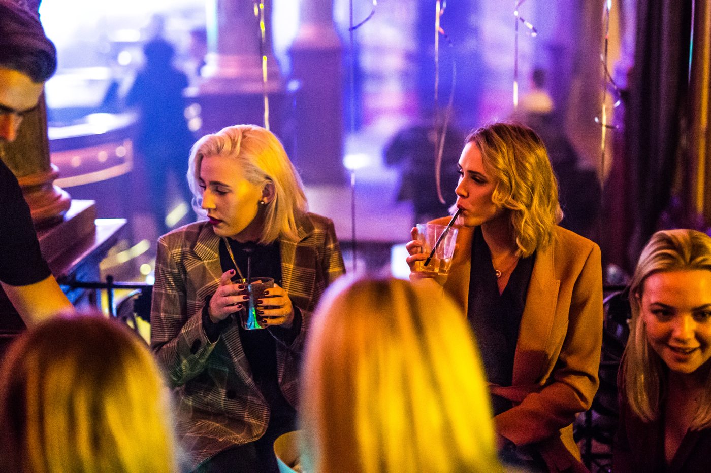 Medlemmar minglar med drinkar i klubbmiljö